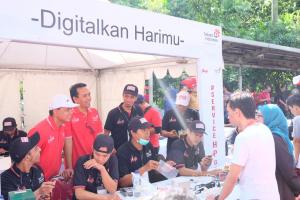    Foto 2: Direktur Human Capital Management Telkom Herdy Harman (tengah) didampingi oleh Executive Vice President Telkom Regional II Teuku Muda Nanta (kiri) meninjau para teknisi "Service 1000 Handphone Gratis" yang sedang memperbaiki handphone masyarakat di area Car Free Day, Jakarta (18/12).