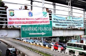 Petugas Satpol PP melakukan pemasangan spanduk himbauan pilkada DKI di JPO Halte Trasnjakarta Mampang, Jakarta, Kamis (13/4/2017). Tujuan pemasangan Spanduk tersebut guna mengajak masyarakat untuk menjaga ketertiban dan Keamanan selama berlangsung pesta demokrasi pemilihan Gubernur dan wakil Gubernur DKI 2017. AKTUAL/Munzir