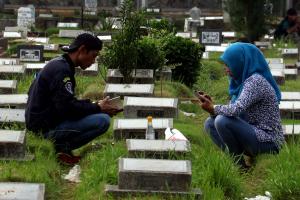 Warga berdoa di makam keluarga saat melakukan ziarah kubur di TPU Karet Tengsin, Jakarta Pusat, Kamis (25/5/2017). Tradisi ziarah kubur tersebut dilakukan warga menjelang bulan Ramadan untuk mendoakan keluarga yang telah meninggal dunia. AKTUAL/Munzir