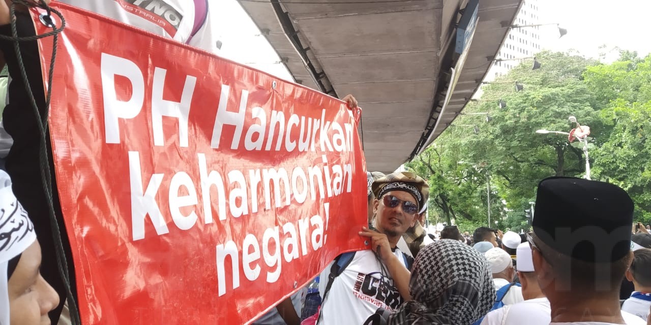 Massa Aksi 812 membentangkan spanduk kegagalan koalisi pemerintah Pakatan Harapan